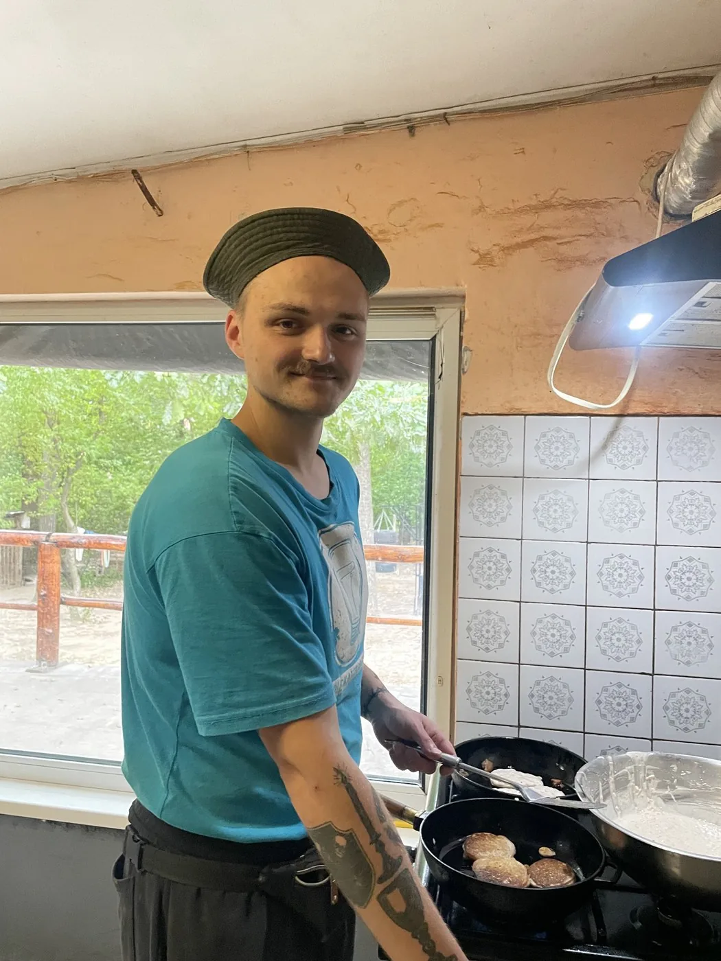 Учасник програми смажить оладки на кухні Дому