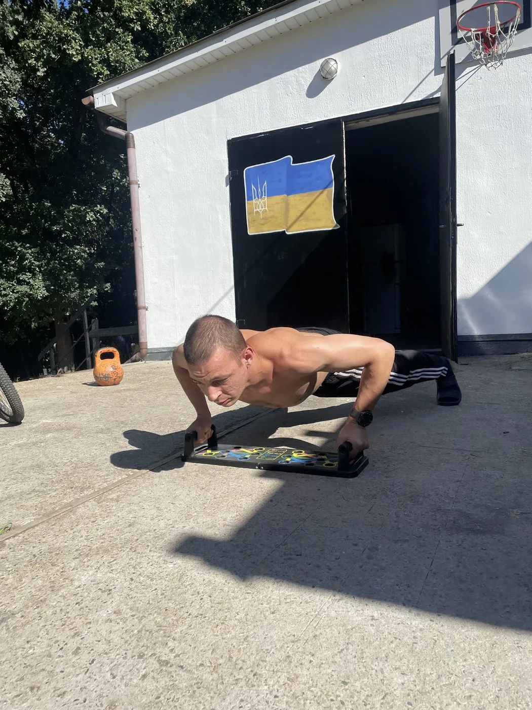 Учасник програми віджимається на подвірʼї центру