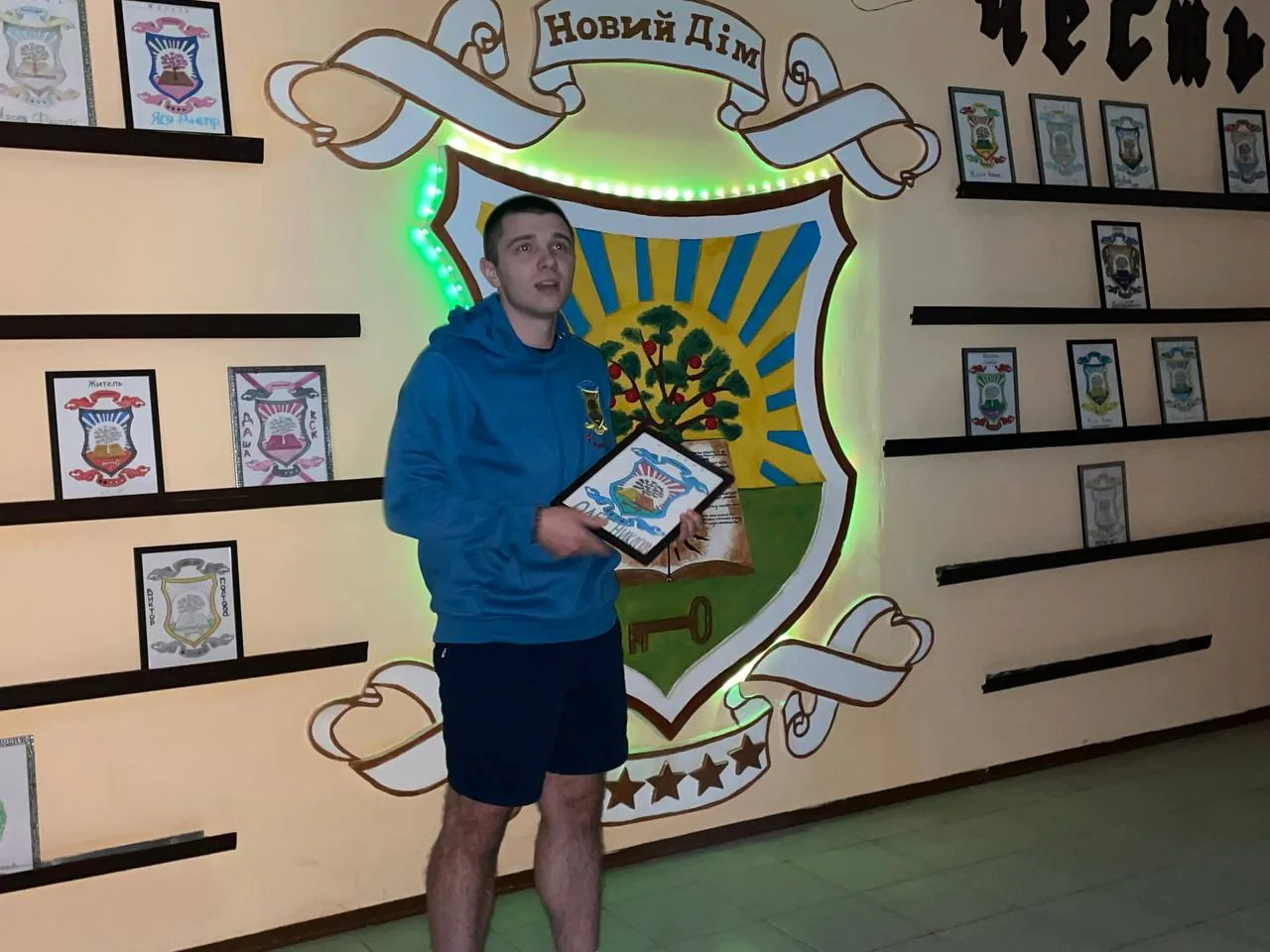 Учасник програми з грамотою біля герба «Новий Дім» у Залі з Гербами