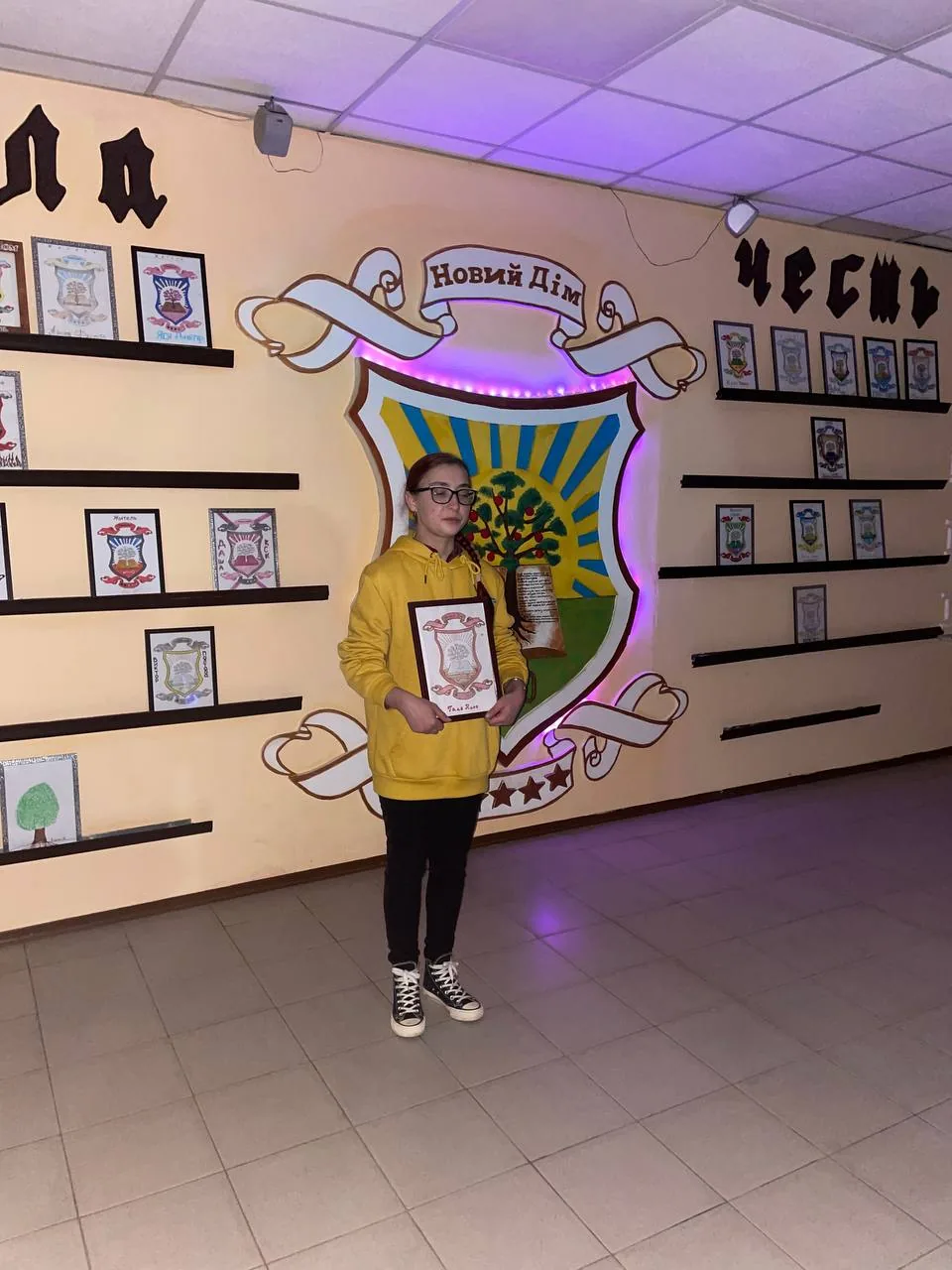Учасниця програми з грамотою біля герба «Новий Дім»