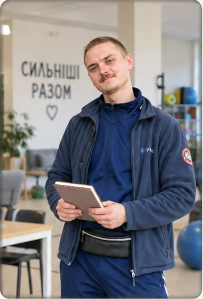 Павло з блокнотом біля напису «Сильніші разом» у залі центру «Джерело»