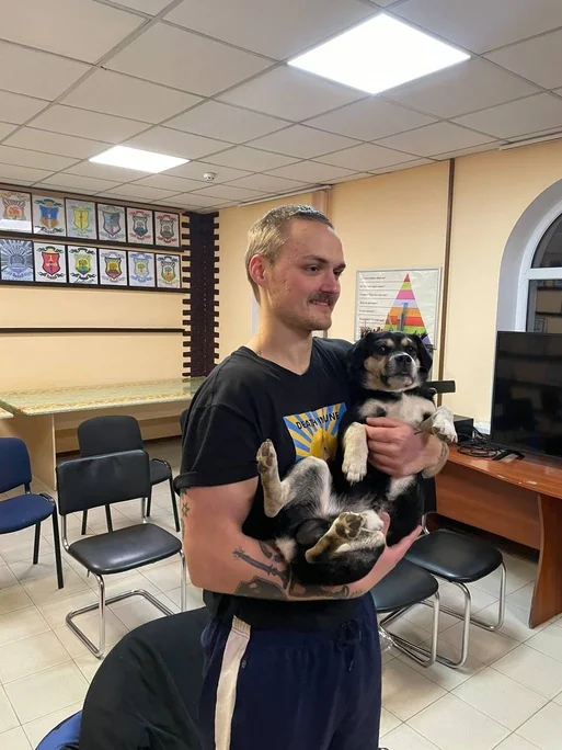 Паша тримає собаку в кімнаті центру в день, коли відзначали шість місяців чистоти
