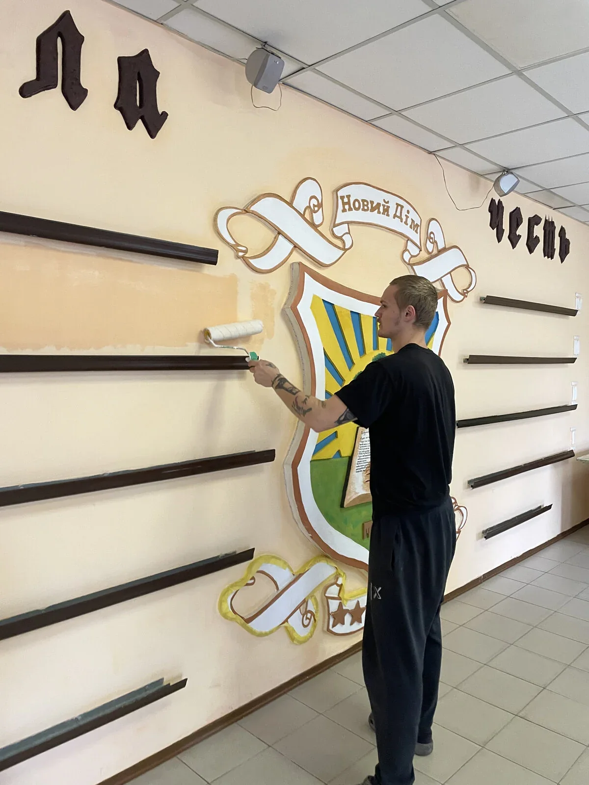 Аккуратная покраска валиком вокруг герба «Новий Дім»